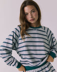Front view of woman wearing Chaser's Resort Stripe Long Sleeve pullover sweater and matching shorts against a plain background