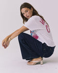 Chaser Coca-Cola Very Cherry Tee in White shown from the side in a casual seated pose, highlighting the relaxed silhouette and lightweight cotton feel from a licensed Coca-Cola collaboration
