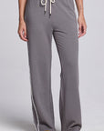 Model wearing Chaser's Soft Graphite Delilah Track Pants in Soft Graphite grey wide-leg track pants with contrast side stripes, front view