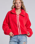 Model wearing Chaser's Cherry Zip-Up in Cherry Bomb red plush zip-up jacket with high collar, front view