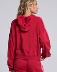 Model wearing Chaser's Merry and Bright Hoodie in Cranberry Velvet with varsity-style Merry and Bright artwork, back view
