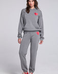 Model wearing Chaser's Dual Tone Heart Jogger and matching Dual Tone Heart Hoodie in Streaky Grey with red heart details, full-body view