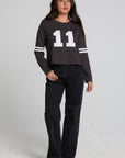 A full body front view of a woman wearing the Chaser 11 Long Sleeve on a neutral background