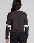 Back view of a woman wearing the Chaser 11 Long Sleeve and jeans on a neutral background