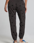Back view of a woman wearing the Chaser Allover Mini Stars Pants on a neutral background