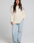A full body front view of a woman wearing the Chaser Antique White Harpur Pullover on a neutral background