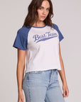Front view of a woman wearing the Chaser Athletics Club Tee on a neutral background with blue jeans