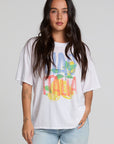Front view of a woman wearing the Chaser Bagged Italy Tee on a neutral background with blue jeans and hand on waist