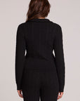Back view of a woman wearing the Chaser Beatrix Black Sweater on a neutral background with pants