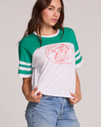 Front view of a woman wearing the Chaser Biker Rider Graphic Tee on a neutral background with both hands on hem of tee