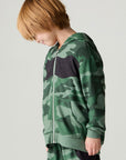 Side view of a boy wearing the Chaser Blocked Camo Boys Hoodie on a neutral background looking down