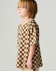 Side view of a boy wearing the Chaser Boys Solara Check Tee on a neutral background with matching pants