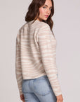 Back view of a woman wearing the Chaser Zebra Dream Striped Cardigan on a neutral background with one hand in pocket