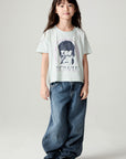 A full body front view of a girl wearing the Chaser David Bowie Stars Bowie Girls Tee on a neutral background