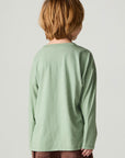 Back view of a boy wearing the Chaser Dino Action Boys Tee on a neutral background with brown pants