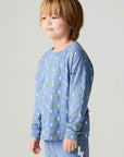 Side angle view of a boy wearing the Chaser Dino Bolts Boys Tee on a neutral background with blue pants