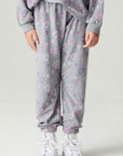 Front view of a girl wearing the Chaser Ditsy Hearts Girls Jogger on a neutral background with matching shirt