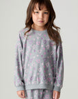 Front view of a girl wearing the Chaser Ditsy Hearts Girls Tee and matching pants on a neutral background with hands down