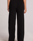 Back view of a woman wearing the Chaser Eliza Black Pants on a neutral background