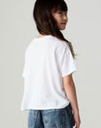 Back view of a girl wearing the Chaser Full Of Love Girls Tee on a neutral background with jeans