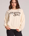Front view of a woman wearing the Chaser How's Your Ap Res Sweatshirt on a neutral background with hands at hem