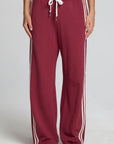Front view of a woman wearing the Chaser Jessee Brick Red Trackpants on a neutral background with arms lowered