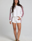 Full body front view of a woman wearing the Chaser Jezz Cloud White Shorts on a neutral background with matching white top