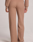 Back view of a woman wearing the Chaser Jorgia Camel Pants on a neutral background