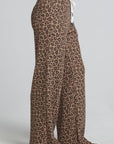 Side view of a woman wearing the Chaser Jorgia Leopard Pant on a neutral background with shoes