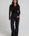 A full body front view of a woman wearing the Chaser Kevin Black Longsleeve on a neutral background