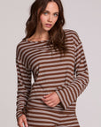 Front view of a woman wearing the Chaser Lunnah Nutty Brown Top and matching striped pants on a neutral background with arm on torso