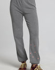 Front view of a woman wearing the Chaser Mini Star Glaze Pants and matching sweatshirt on a neutral background