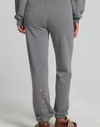 Back view of a woman wearing the Chaser Mini Star Glaze Pants and matching grey sweatshirt on a neutral background