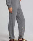 Side view of a woman wearing the Chaser Mini Star Glaze Pants and sweatshirt on a neutral background