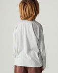 Back view of a boy wearing the Chaser Moto Patches Boys Tee on a neutral background with arms lowered
