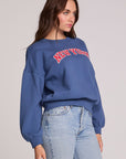 Front view of a woman wearing the Chaser New York Long Sleeve on a neutral background with jeans