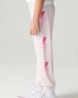 Side view of a girl wearing the Chaser Power Bolt Girls Jogger and sneakers on a neutral background