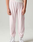 Side view of a girl wearing the Chaser Power Bolt Girls Jogger and white sneakers on a neutral background