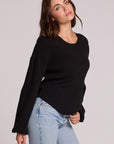 Side view of a woman wearing the Chaser Ruthy Black Fullsleeve Top on a neutral background with jeans and hand on hem