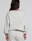 Back view of a woman wearing the Chaser Shocking Bolt Sweatshirt on a neutral background with pants