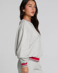Side view of a woman wearing the Chaser Shocking Bolt Sweatshirt on a neutral background with matching pants