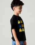 Side view of a boy wearing the Chaser Spooky Friends Boys Tee on a neutral background with bluejeans