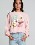 Front view of a woman wearing the Chaser Sporty Patches Long Sleeve Top and blue jeans on a neutral background with hands in pockets