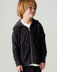 Front view of a boy wearing the Chaser Storm Boys Hoodie on a neutral background with pants looking over one shoulder