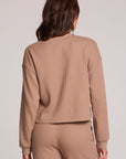 Back view of a woman wearing the Chaser Suzzans Camel Cropped Sweatshirt and pants on a neutral background
