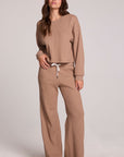 A full body front view of a woman wearing the Chaser Suzzans Camel Cropped Sweatshirt on a neutral background