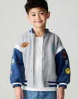 Front view of a boy wearing the Chaser Team Spirit Boys Jacket on a neutral background with jeans and white shirt
