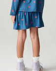 Back view of a girl wearing the Chaser Tiny Hearts Girls Skirt on a neutral background
