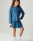 Full body front view of a girl wearing the Chaser Tiny Hearts Girls Skirt on a neutral background with matching shirt