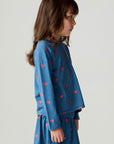 Side view of a girl wearing the Chaser Tiny Hearts Girls Tee on a neutral background with arms at sides